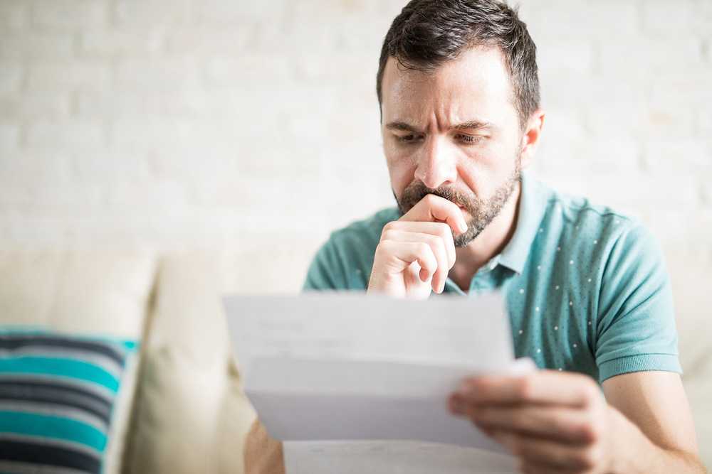 A man ponders the information on a piece of paper